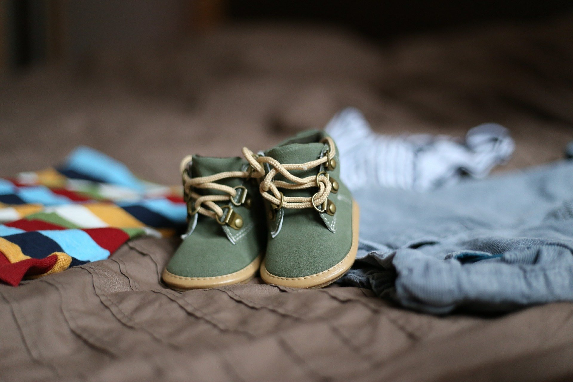 Kuvassa vauvan kengät ja vaatteita.