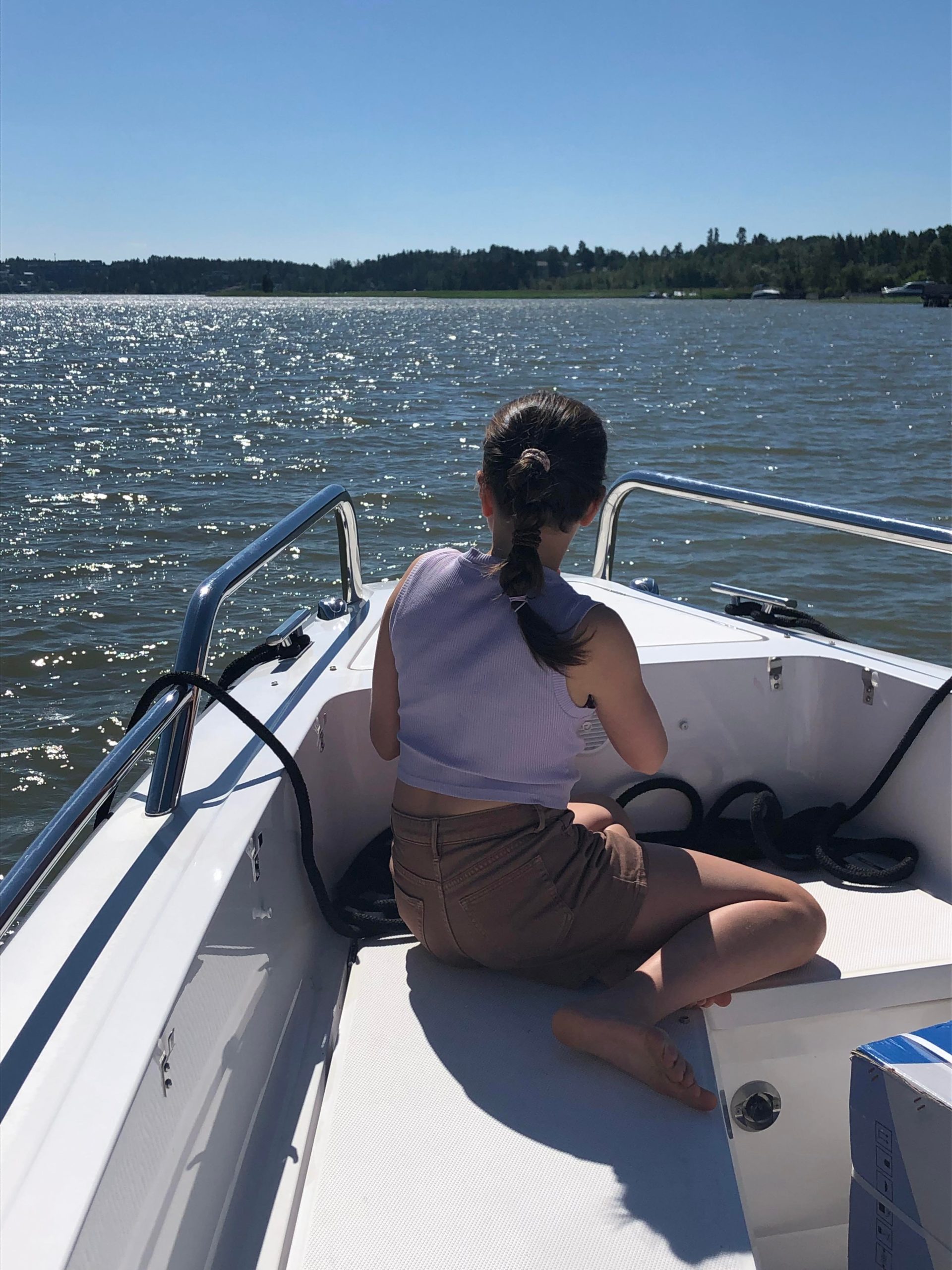 Kymmenvuotias istuu veneen keulassa