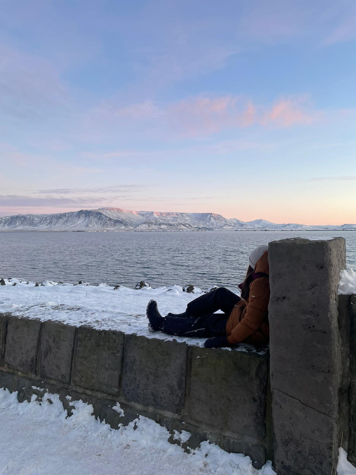TYttö istuu muurilla Reykjavikissa