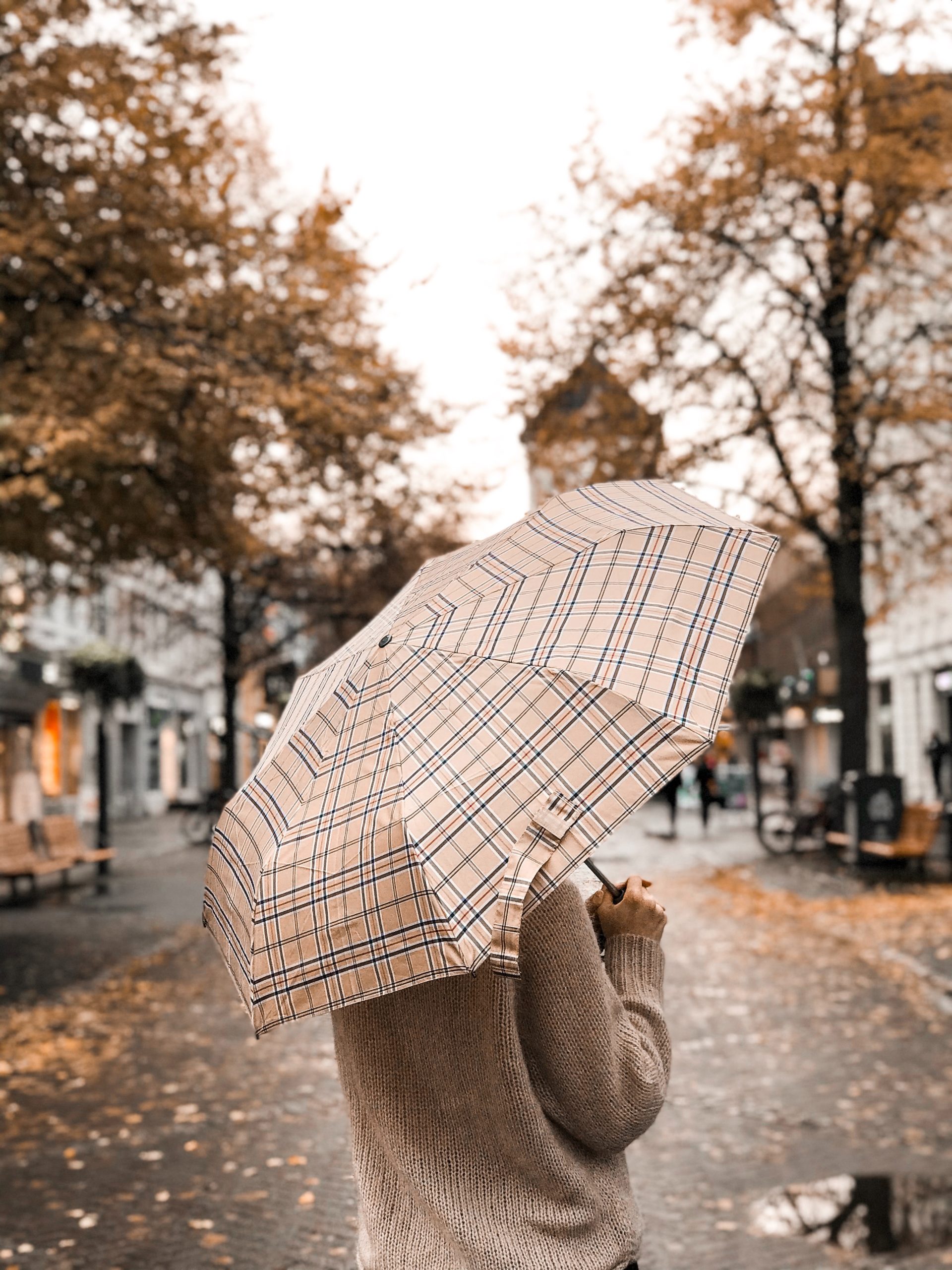 Nainen sateenvarjo kädessä