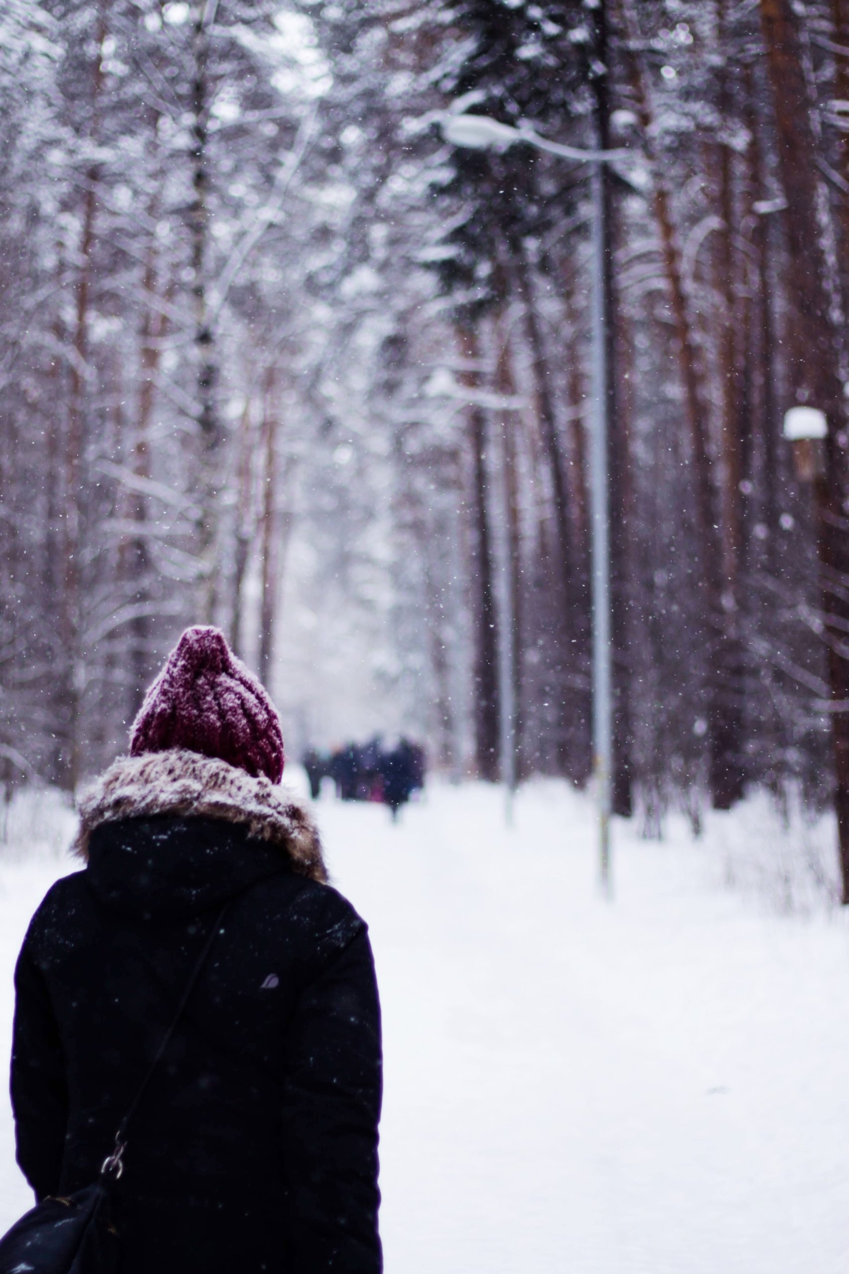 Nainen kävelee lumisessa maisemassa