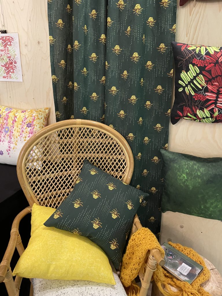 Kuva tuolista jossa on tyyny ja taustalla on kangas.
